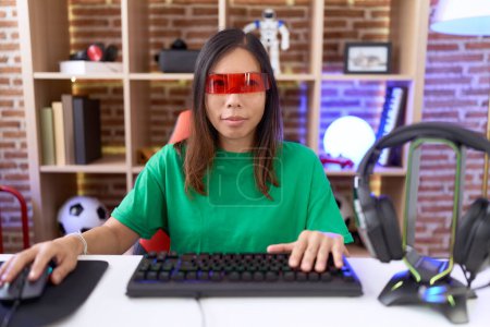 Photo for Middle age chinese woman wearing virtual reality glasses depressed and worry for distress, crying angry and afraid. sad expression. - Royalty Free Image