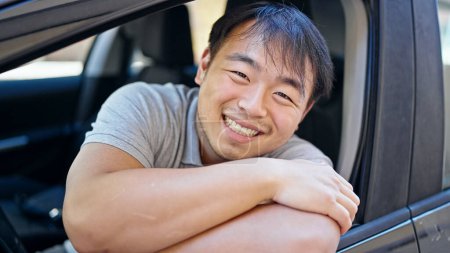 Foto de Sonriendo confiado sentado en el coche en la calle - Imagen libre de derechos