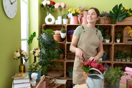 Téléchargez les photos : Jeune belle femme fleuriste coupe f à la boutique de fleurs - en image libre de droit