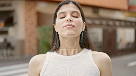 Téléchargez les photos : Jeune belle femme hispanique respirant les yeux fermés sur la terrasse du café - en image libre de droit