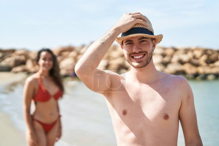 Photo for Young hispanic couple tourists wearing swimsuit standing at seaside - Royalty Free Image