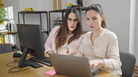 Foto de Dos mujeres trabajadoras de negocios que usan computadoras y computadoras portátiles trabajando en la oficina - Imagen libre de derechos