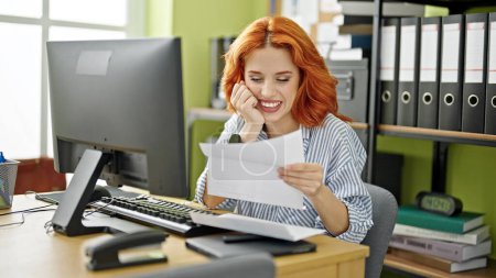 Photo for Young redhead woman business worker using computer reading letter with winner expression at office - Royalty Free Image