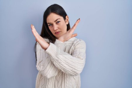 Téléchargez les photos : Jeune femme brune debout sur fond bleu expression de rejet croisant les bras faisant signe négatif, visage en colère - en image libre de droit