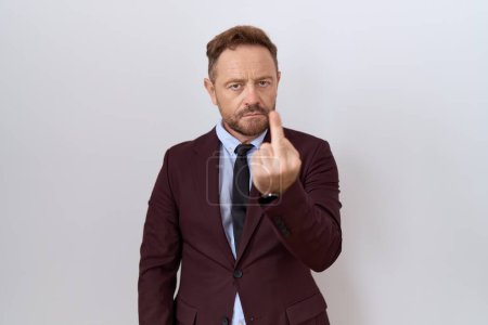 Foto de Middle age business man with beard wearing suit and tie showing middle finger, impolite and rude fuck off expression - Imagen libre de derechos