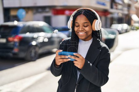 Photo for African american woman smiling confident playing video game at street - Royalty Free Image