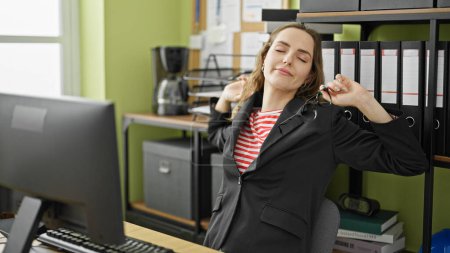 Foto de Joven mujer rubia trabajadora de negocios estirándose en la oficina - Imagen libre de derechos