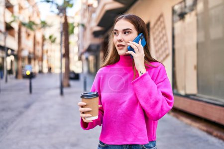 Photo for Young woman talking on the smartphone drinking coffee at street - Royalty Free Image