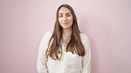 Foto de Young beautiful hispanic woman standing with serious expression over isolated pink background - Imagen libre de derechos