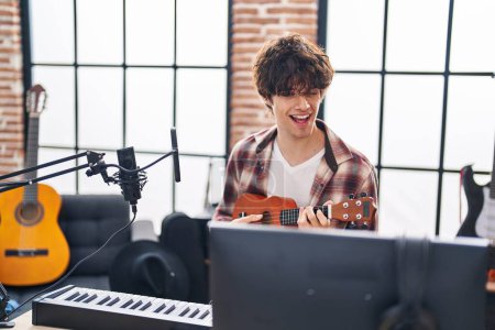Foto de Joven músico hispano cantando la canción ukelele en el estudio de música - Imagen libre de derechos