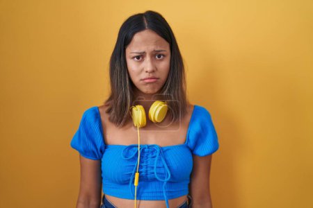 Photo for Hispanic young woman standing over yellow background depressed and worry for distress, crying angry and afraid. sad expression. - Royalty Free Image