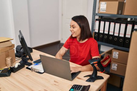 Téléchargez les photos : Jeune belle hispanique femme ecommerce travailleur d'affaires en utilisant un ordinateur portable au bureau - en image libre de droit