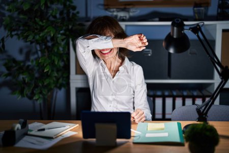 Photo for Middle age woman working at the office at night smiling cheerful playing peek a boo with hands showing face. surprised and exited - Royalty Free Image