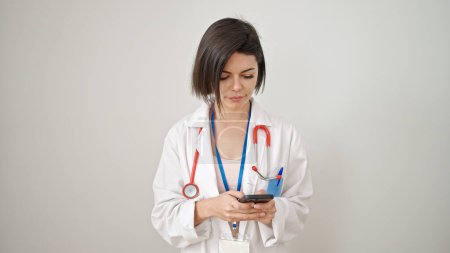 Foto de Mujer joven caucásica médico confiado usando teléfono inteligente sobre fondo blanco aislado - Imagen libre de derechos