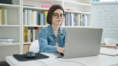 Téléchargez les photos : Jeune étudiante caucasienne utilisant un ordinateur portable étudiant à l'université salle de classe - en image libre de droit