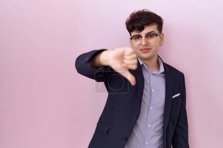 Photo for Young non binary man with beard wearing suit and tie looking unhappy and angry showing rejection and negative with thumbs down gesture. bad expression. - Royalty Free Image