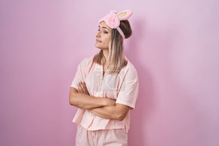 Photo for Blonde caucasian woman wearing sleep mask and pajama looking to the side with arms crossed convinced and confident - Royalty Free Image