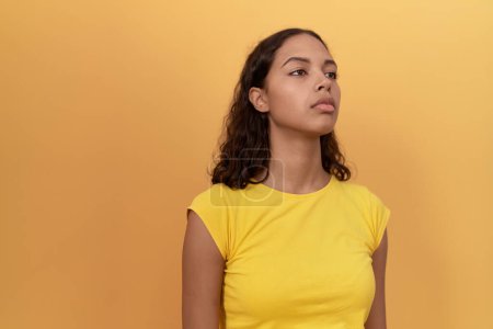 Téléchargez les photos : Young african american woman standing with serious expression over isolated yellow background - en image libre de droit