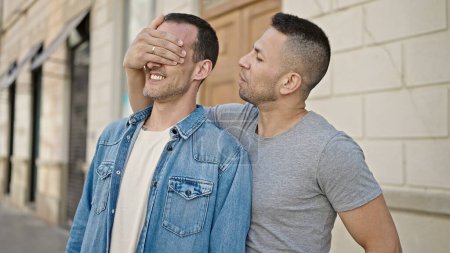 Téléchargez les photos : Deux hommes couple couvrant les yeux avec la main pour la surprise à la rue - en image libre de droit