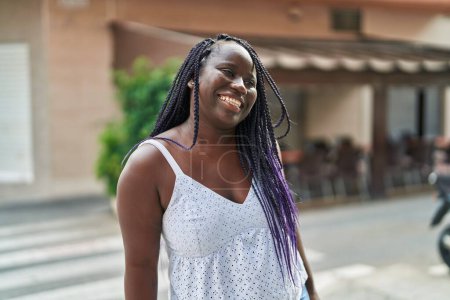 Foto de Mujer afroamericana sonriendo confiada mirando a un lado en la terraza de la cafetería - Imagen libre de derechos