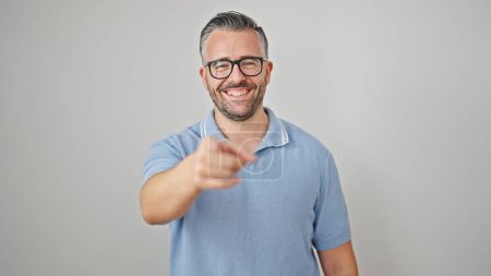 Foto de Hombre de pelo gris sonriendo confiado apuntando a la cámara sobre un fondo blanco aislado - Imagen libre de derechos