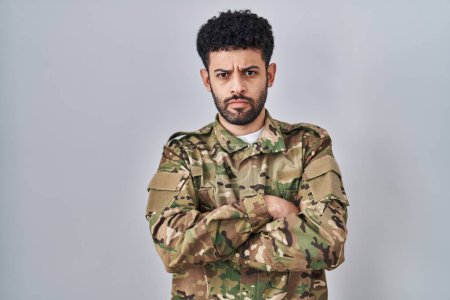 Téléchargez les photos : Homme arabe portant un uniforme de camouflage militaire sceptique et nerveux, désapprouvant l'expression sur le visage avec les bras croisés. personne négative. - en image libre de droit