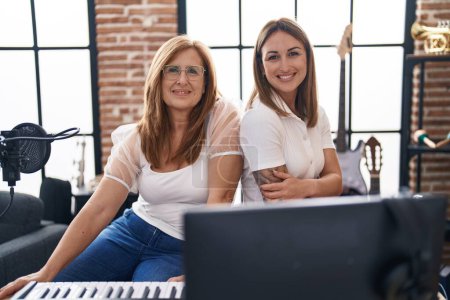 Photo for Mother and daughter musicians smiling confident at music studio - Royalty Free Image