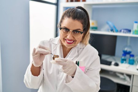 Photo for Young beautiful plus size woman scientist holding mushroom with tweezers at pharmacy - Royalty Free Image