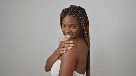 Foto de Mujer afroamericana sonriendo confiada tocando hombro sobre fondo blanco aislado - Imagen libre de derechos