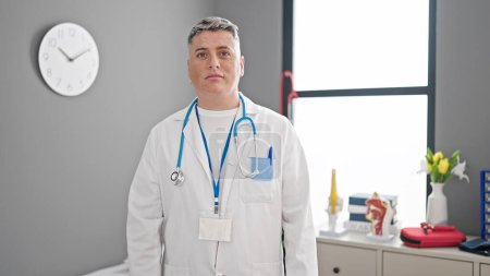Photo for Young caucasian man doctor standing with serious expression at the clinic - Royalty Free Image