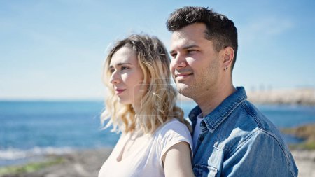 Téléchargez les photos : Homme et femme couple souriant confiant debout ensemble au bord de la mer - en image libre de droit