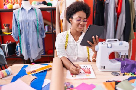 Téléchargez les photos : African american woman tailor using touchpad drawing clothing design at atelier - en image libre de droit