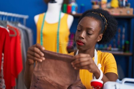 Photo for African american woman tailor holding jeans at sewing studio - Royalty Free Image