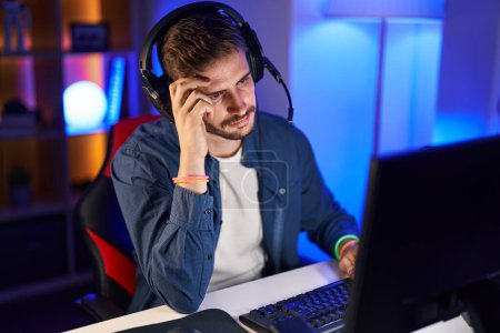 Foto de Young caucasian man streamer stressed using computer at gaming room - Imagen libre de derechos