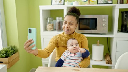 Photo for Mother and son make selfie by smartphone breastfeeding baby at dinning room - Royalty Free Image
