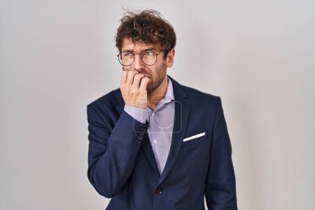 Foto de Hombre de negocios hispano con gafas que se ven estresados y nerviosos con las manos en la boca mordiendo uñas. problema de ansiedad. - Imagen libre de derechos