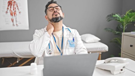 Photo for Young latin man doctor stressed working at clinic - Royalty Free Image