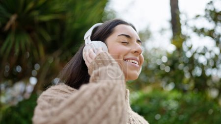 Photo for Young beautiful hispanic woman smiling confident listening to music at park - Royalty Free Image
