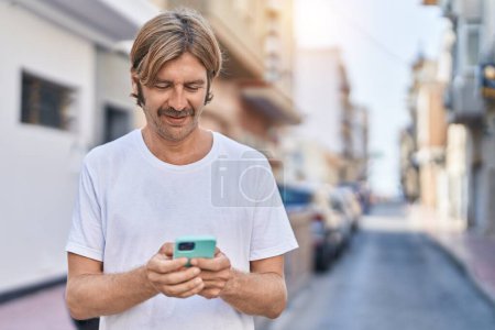 Téléchargez les photos : Young blond man smiling confident using smartphone at park - en image libre de droit