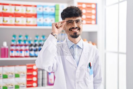 Photo for Young hispanic man pharmacist smiling confident standing at pharmacy - Royalty Free Image