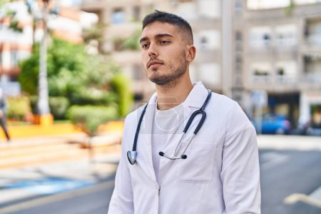 Photo for Young hispanic man doctor standing with relaxed expression at park - Royalty Free Image