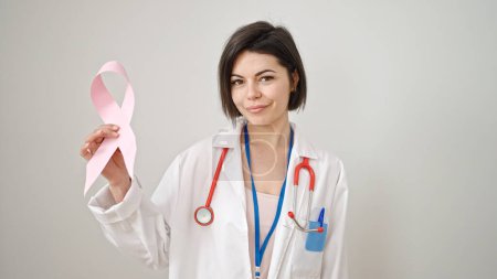 Foto de Mujer joven caucásica médico sosteniendo la conciencia de cáncer de mama cinta rosa sobre fondo blanco aislado - Imagen libre de derechos