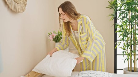 Photo for Young blonde woman make bed at bedroom - Royalty Free Image