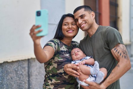 Téléchargez les photos : Famille hispanique s'embrasser faire du selfie par smartphone à la rue - en image libre de droit