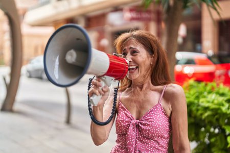 Téléchargez les photos : Middle age woman using megaphone screaming at street - en image libre de droit