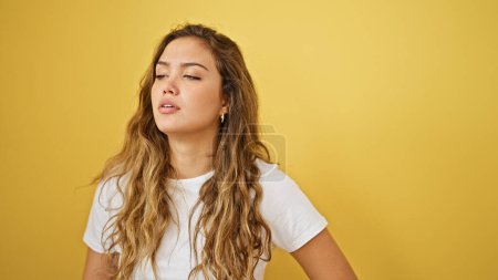 Téléchargez les photos : Jeune belle femme hispanique debout avec une expression sérieuse sur fond jaune isolé - en image libre de droit