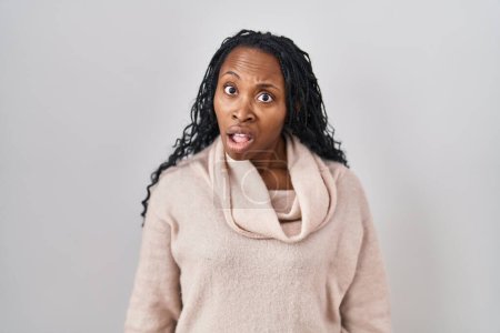 Photo for African woman standing over white background in shock face, looking skeptical and sarcastic, surprised with open mouth - Royalty Free Image