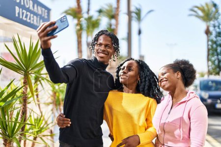Foto de Amigos afroamericanos de pie juntos haciendo selfie junto al teléfono inteligente en la calle - Imagen libre de derechos