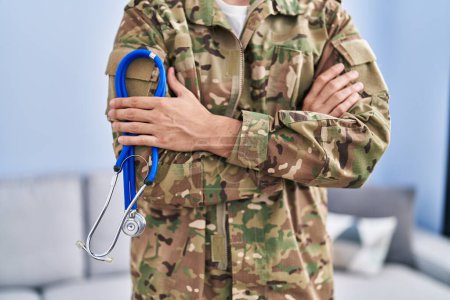 Foto de Young hispanic man army soldier doctor holding stethoscope at home - Imagen libre de derechos