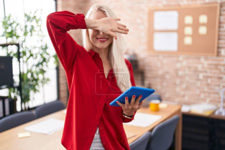 Photo for Caucasian woman working at the office with tablet smiling cheerful playing peek a boo with hands showing face. surprised and exited - Royalty Free Image